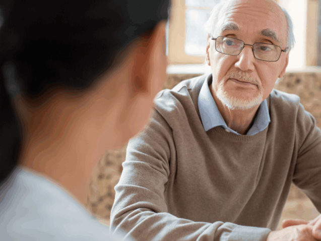 osoba mówi do seniora, a ten słucha