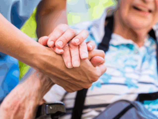 opiekunka trzyma seniora za rękę