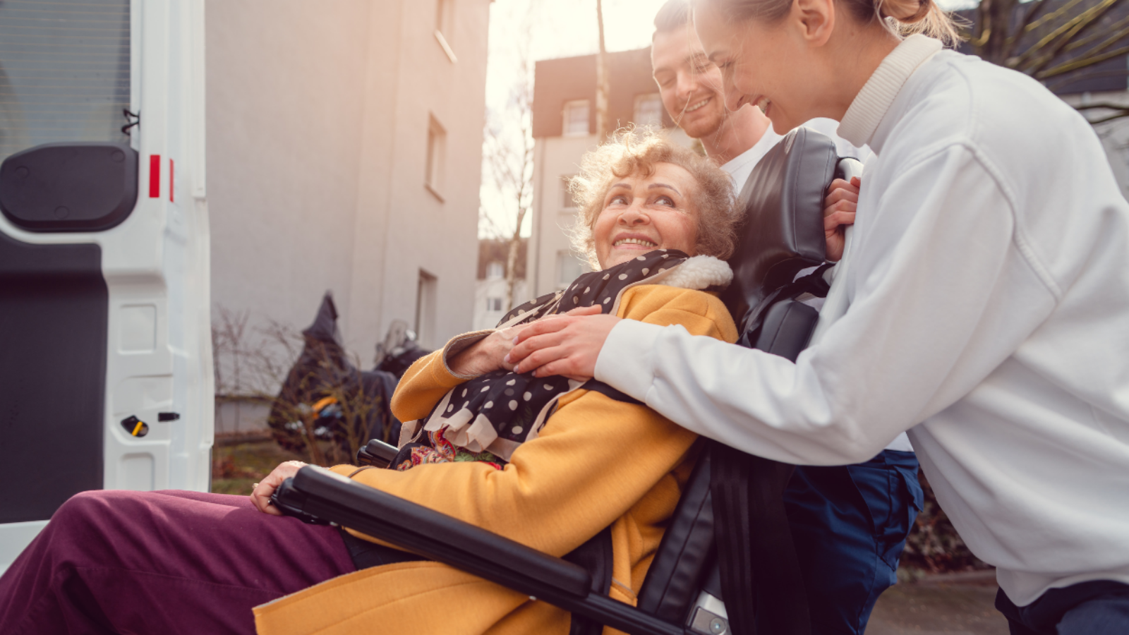 seniorka na wózku jest wprowadzana do samochodu